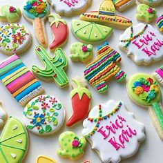 many decorated cookies on a table with writing and decorations in the shape of cactuses