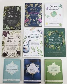 twelve books are lined up on a white surface with green, blue and purple covers