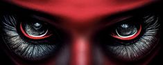 the eyes of an alien creature with red and black markings on their face are shown