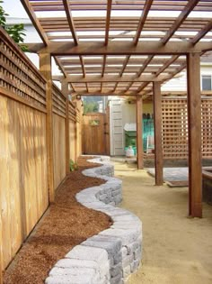 a wooden pergolated area with rocks and gravel