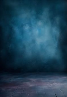 an empty room with a wooden floor and dark blue wall behind the area is covered in clouds