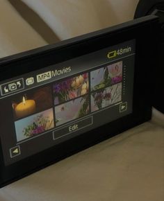 an image of a video camera with pictures on the screen and candles in the background