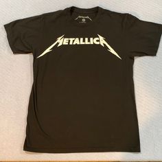 This Metallica T-Shirt Is 100% Cotton. It Is New Without Tags. Has A Vintage Weathered Look. See Photo. Band Merch Crew Neck T-shirt With Logo, Band Logo Graphic Tee With Crew Neck, Graphic Tee With Band Logo And Crew Neck, Band Merch Cotton Tops With Logo Print, Black Short Sleeve Tops With Band Logo, Black Short Sleeve Top With Band Logo, Cotton Crew Neck Top With Band Logo, Black Band Merch T-shirt With Logo, Black Band Logo Crew Neck Top