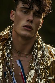 a young man wearing gold chains and necklaces