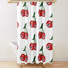 a white shower curtain with red cherries on it and eyeballs in the center