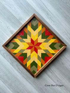 a wooden box with a colorful design on it's lid sitting on the floor