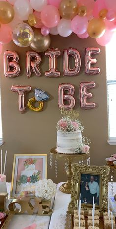 a table topped with cake and balloons in front of a sign that says bride to be