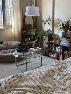 a living room with a couch, coffee table and bookshelf in the corner