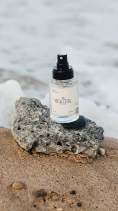 a bottle of perfume sitting on top of a rock