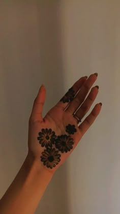 a woman's hand with hendix on it and flowers painted on the palm