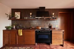 a stove top oven sitting inside of a kitchen next to wooden cabinets and counter tops