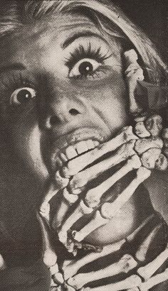 a black and white photo of a woman covering her face with bones in front of her mouth