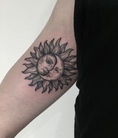 a sunflower with a skull in the middle on someone's left arm that is black and white