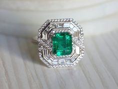 Natural Emerald Art Deco engagement ring, Antique engagement ring, 2.5 carat Emerald cut, Diamond baguette halo engagement ringThis unique emerald ring comes with 2.5 carat Emerald and is surrounded by diamonds is made for special occasions!Same design can be made also with other custom gemstones per request. Product details:- 14k or 18k Solid gold- approx. 2.5 carats Genuine Great quality emerald with a certificate of authenticity.- approx. 1.22 carats genuine G VS-SI diamonds - Made to order - Luxury Emerald Cluster Ring With Halo Design, Luxury Modern Octagon Emerald Ring, Luxury Dazzling Emerald Ring With Halo Design, Art Deco Gia Certified Emerald Ring As Gift, Gia Certified Art Deco Emerald Ring Gift, Art Deco Emerald Ring With Accent Stones For Anniversary, Antique Emerald Engagement Ring, Baguette Halo, Emerald Art