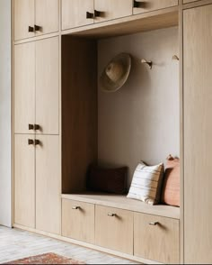 a room with some wooden cabinets and pillows on the shelf next to eachother