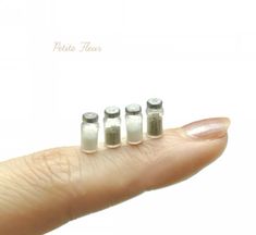 three tiny pill shaped objects sitting on top of a persons finger in front of a white background