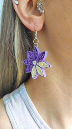 a close up of a person wearing earrings with flowers on it's back end