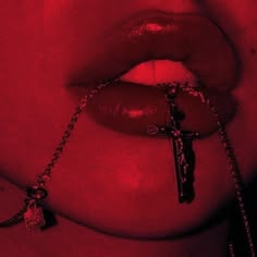 a close up of a person with a cross on her lip and chain around their neck