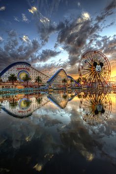 an amusement park with a ferris wheel at sunset