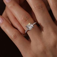 a woman's hand with a diamond ring on top of her finger and an engagement band