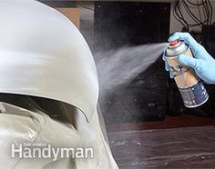 a person sprays disinfection on a white helmet