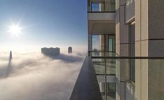 the sun is shining above the clouds in front of an apartment building with balconies