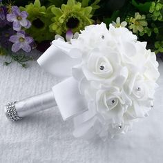 a bridal bouquet with white flowers and jewels