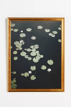 a painting with water lilies floating on it's surface in front of a white wall