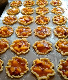 many small pies are lined up on a baking sheet and ready to be baked