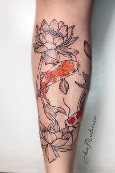 a woman's leg with fish and lotus tattoo on it