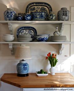 the shelves are filled with blue and white dishes