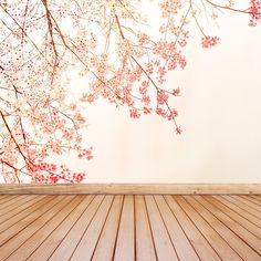 an empty room with wooden floor and cherry blossoms on the wall