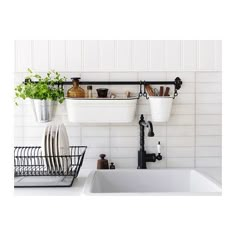 the kitchen sink is filled with dishes and utensils hanging from the wall above it