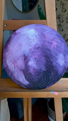 a purple object sitting on top of a wooden chair