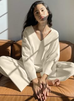 a woman sitting on top of a brown couch