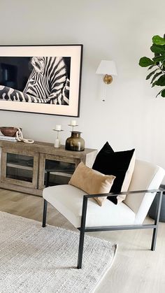 a living room with a zebra painting on the wall and a chair in front of it