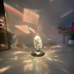 a table topped with a glass vase filled with water and light shining through the window