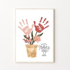 a mothers day card with hand prints and flowers in a flower pot on the table