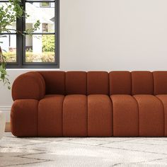 an orange couch sitting on top of a white rug