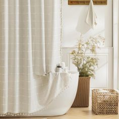 a bath room with a shower curtain and a basket on the floor next to it