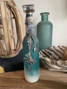 a bottle with an octopus on it sitting on a table next to other vases