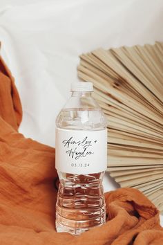 a bottle of water sitting on top of an orange blanket