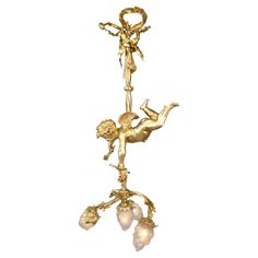 a gold colored chandelier with cherubs and flowers hanging from the ceiling