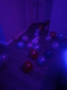 balloons and streamers are scattered on the floor in an empty room with purple lighting