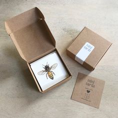 a box with a bee on it next to a small card in the middle and a sticker that says mini cards