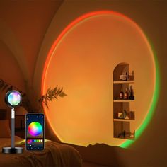 a cell phone is sitting next to a colorful light in a room with a book shelf