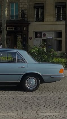 a blue car is parked on the side of the road