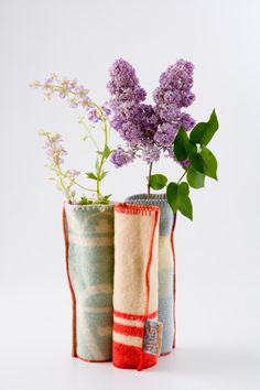 two vases with flowers in them sitting on a table