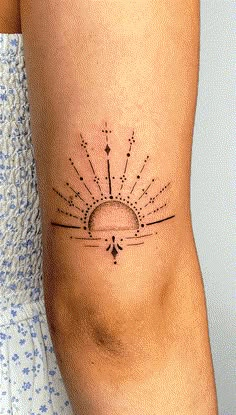 a woman's arm with a sun tattoo on the back of her left leg