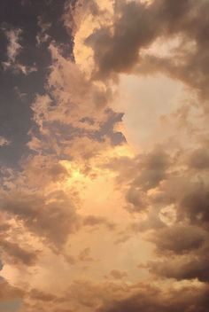 an airplane is flying in the sky with clouds behind it and sun peeking through the clouds